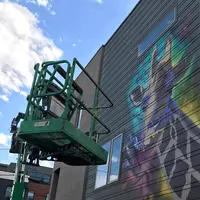 a scissor lift next to a colorcon mural